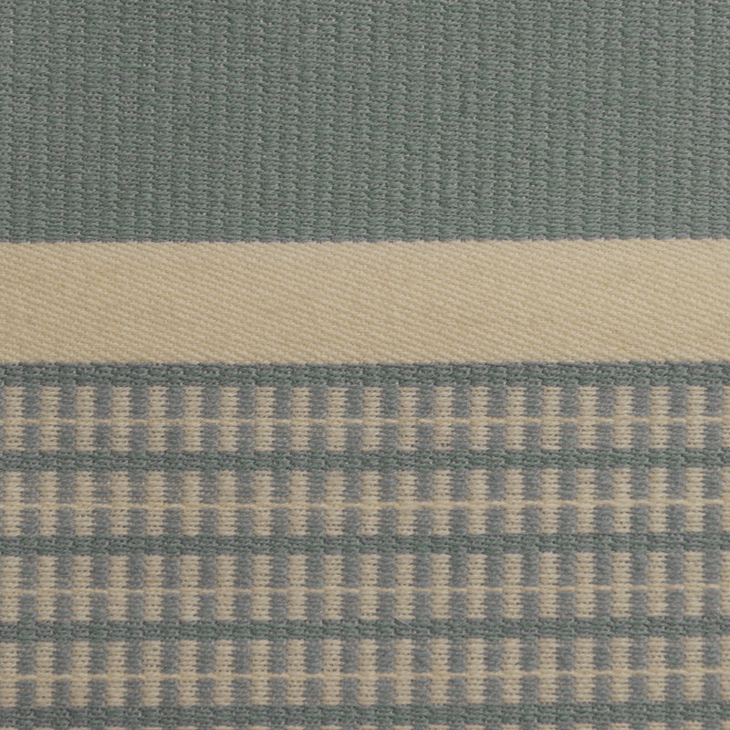 Close-up of the light blue Danish woven wool fabric from Kjellerup Væveri, featuring a distinctive checkered pattern. The fabric showcases a blend of light blue and light beige tones, reflecting the exquisite craftsmanship and refined texture characteristic of Kjellerup Væveri's designs, used in the Kelly Rutherford x August Sandgren Limited Edition Collection.